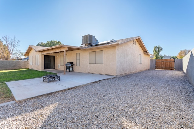 back of property featuring central AC, a patio area, and solar panels