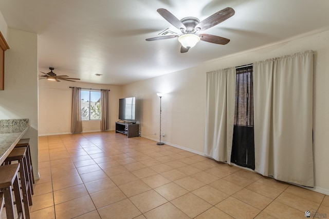 unfurnished living room featuring light tile patterned flooring and ceiling fan