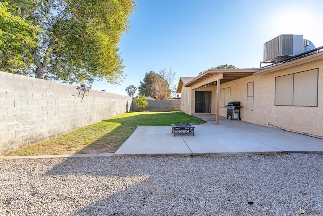 view of yard with central AC unit, a fire pit, and a patio area