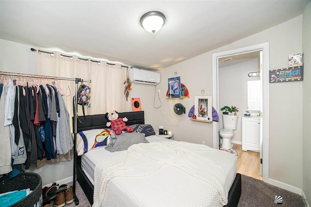 bedroom with light hardwood / wood-style flooring, ensuite bath, a wall mounted AC, and lofted ceiling