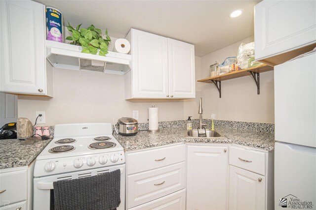 kitchen featuring white cabinets, white appliances, light stone counters, and sink