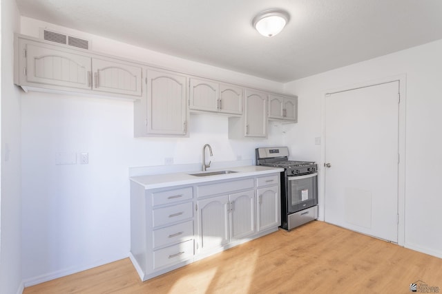 kitchen featuring light hardwood / wood-style flooring, gas stove, and sink