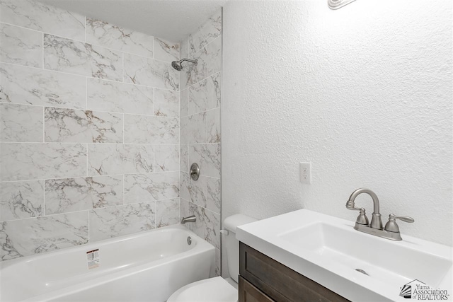 full bathroom featuring tiled shower / bath, vanity, and toilet