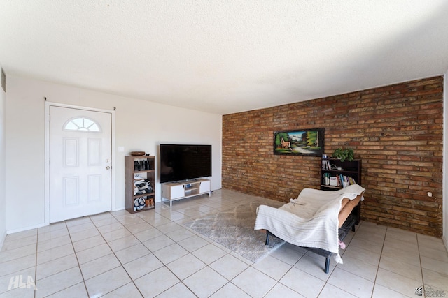 tiled living room with a textured ceiling and brick wall