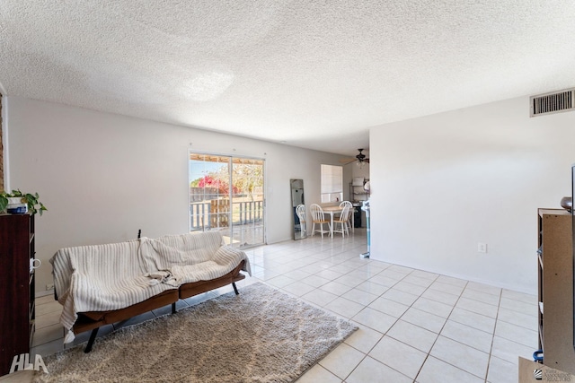 tiled living room with a textured ceiling and ceiling fan