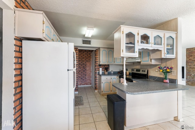 kitchen featuring kitchen peninsula, electric stove, white fridge, brick wall, and light tile patterned flooring