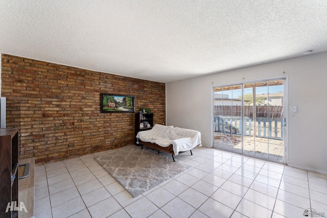 unfurnished room featuring brick wall, a textured ceiling, and light tile patterned floors