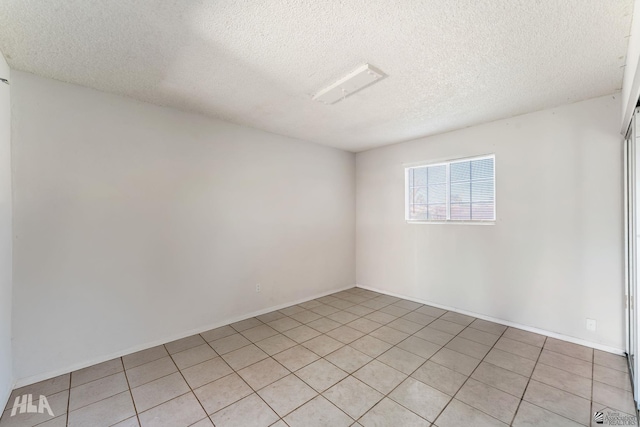 tiled spare room with a textured ceiling