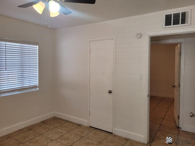 unfurnished bedroom featuring light tile patterned floors and ceiling fan