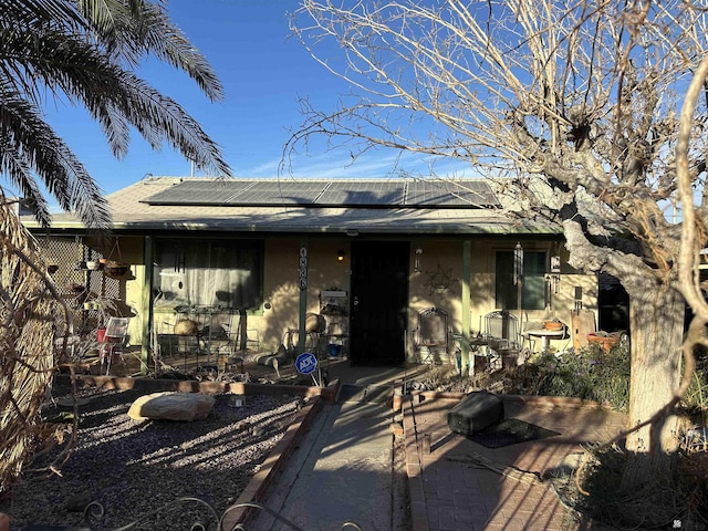 rear view of house with a patio area and solar panels