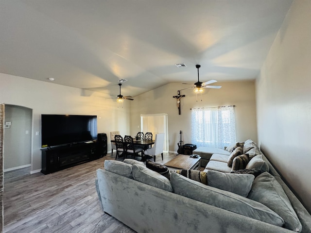 living area with visible vents, wood finished floors, lofted ceiling, and ceiling fan