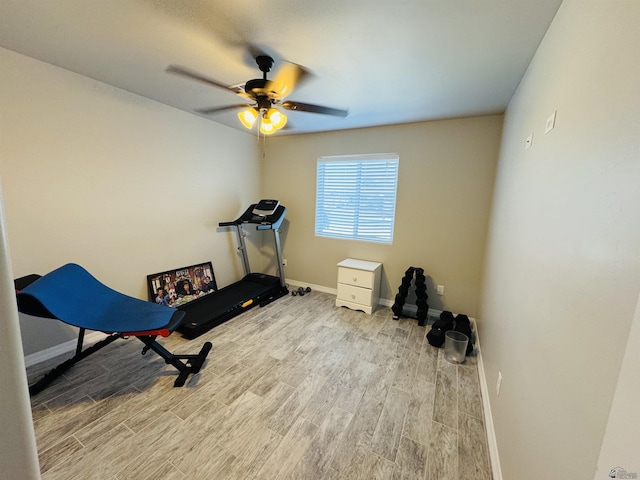 workout room with baseboards, ceiling fan, and wood finished floors