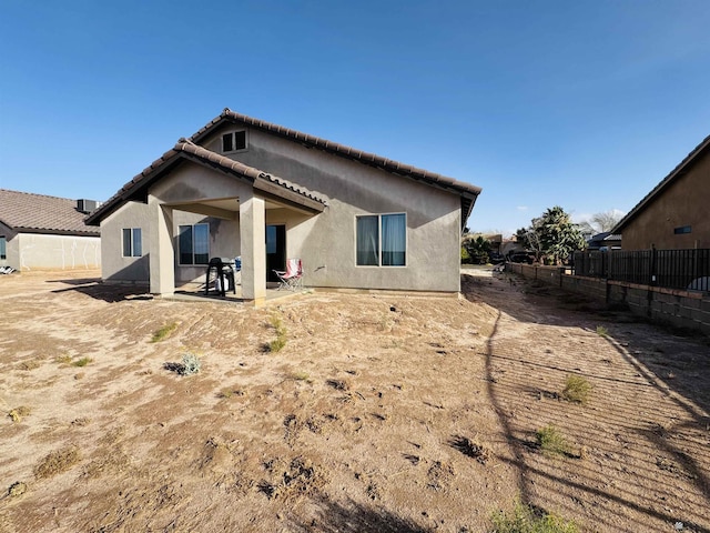 back of house with stucco siding, a patio, fence, and a tiled roof