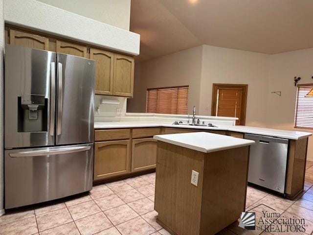 kitchen with light tile patterned flooring, sink, a center island, appliances with stainless steel finishes, and kitchen peninsula