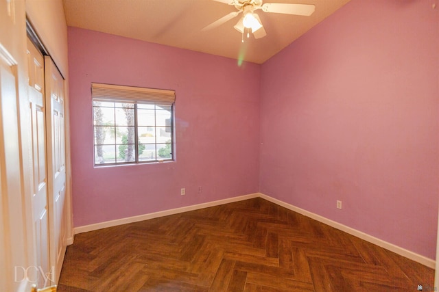 spare room with dark parquet floors and ceiling fan