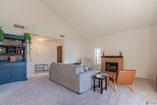 living area with visible vents, light carpet, high vaulted ceiling, and a brick fireplace