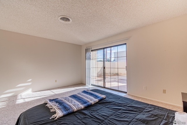 unfurnished bedroom with access to exterior, visible vents, carpet floors, and a textured ceiling