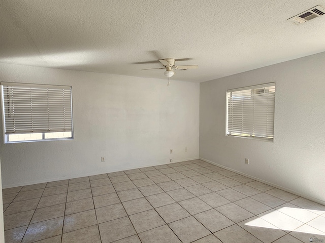 unfurnished room with ceiling fan and a textured ceiling