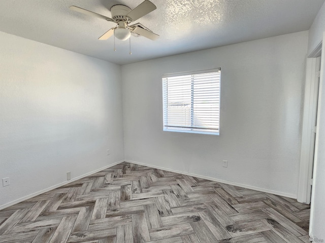 unfurnished room featuring a textured ceiling, light parquet floors, and ceiling fan