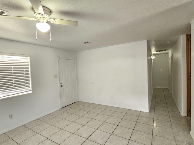 tiled spare room featuring ceiling fan and a textured ceiling