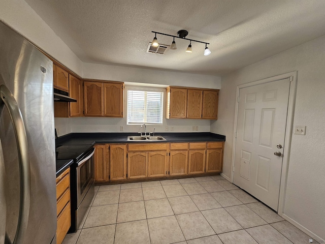 kitchen with sink, appliances with stainless steel finishes, a textured ceiling, and light tile patterned floors