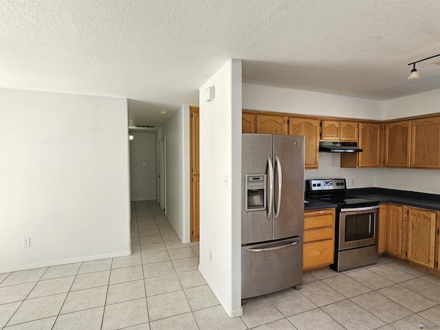 kitchen featuring a textured ceiling, appliances with stainless steel finishes, and light tile patterned floors