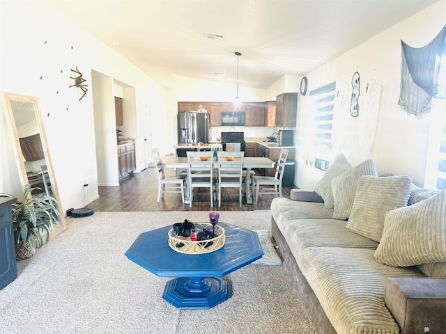 living room featuring vaulted ceiling and hardwood / wood-style flooring