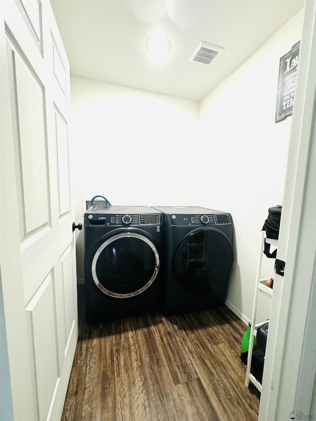 laundry room featuring washing machine and dryer and dark hardwood / wood-style floors