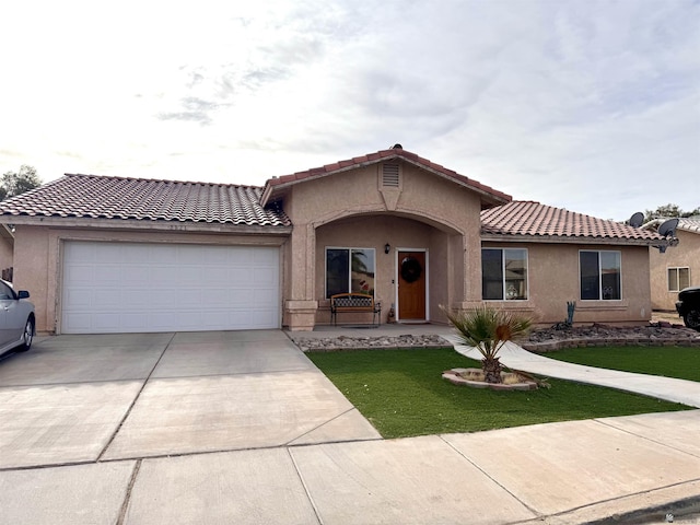 mediterranean / spanish-style home with a garage and a front lawn