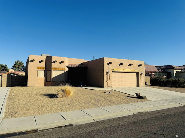 pueblo-style house featuring a garage