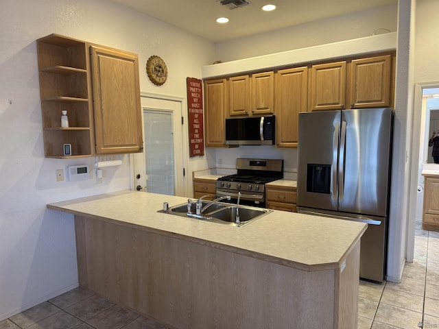 kitchen with a sink, appliances with stainless steel finishes, a peninsula, light tile patterned flooring, and open shelves