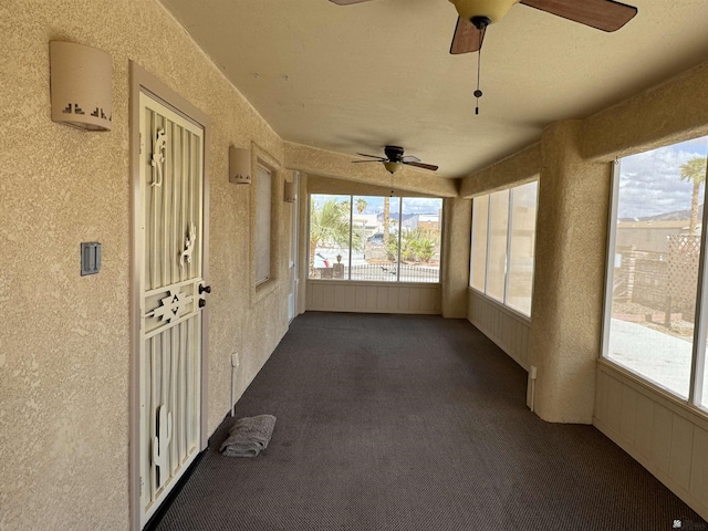 unfurnished sunroom with a ceiling fan