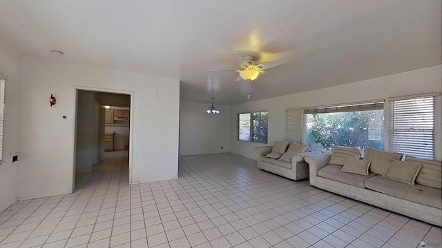 unfurnished living room featuring light tile patterned flooring and ceiling fan with notable chandelier