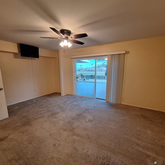 carpeted empty room featuring a ceiling fan