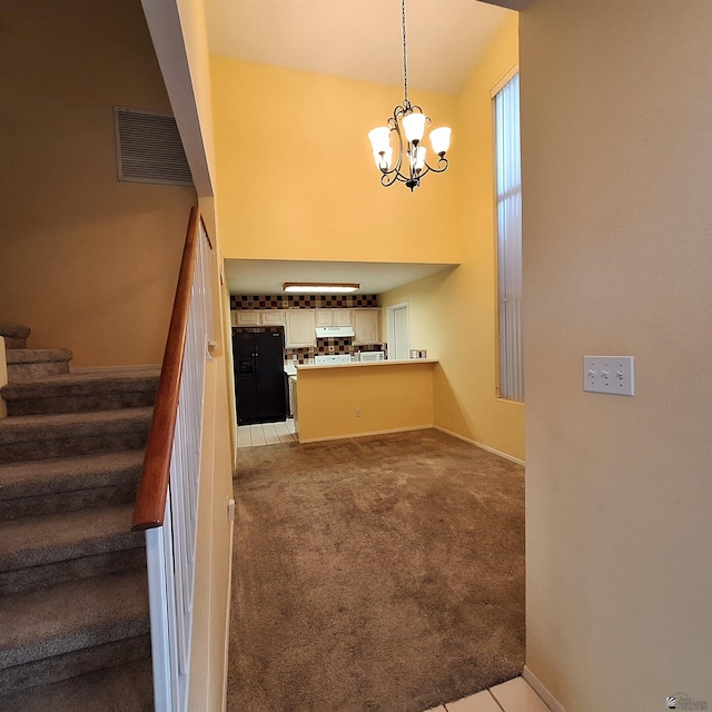 staircase featuring a chandelier, baseboards, visible vents, and carpet flooring