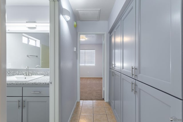 hallway with sink and light carpet