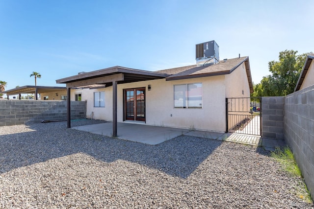 rear view of property with central air condition unit and a patio area