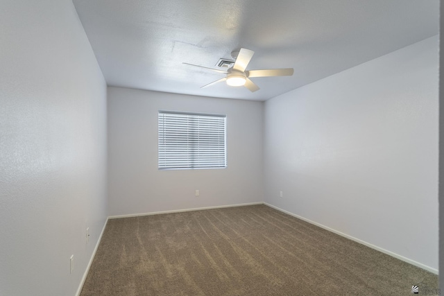 unfurnished room with ceiling fan and dark carpet