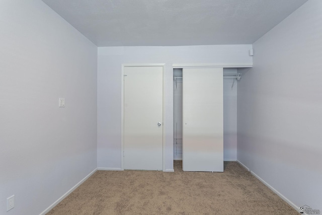 unfurnished bedroom featuring light colored carpet and a closet