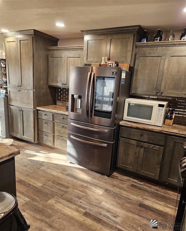 kitchen featuring hardwood / wood-style floors, dark brown cabinets, and stainless steel fridge with ice dispenser