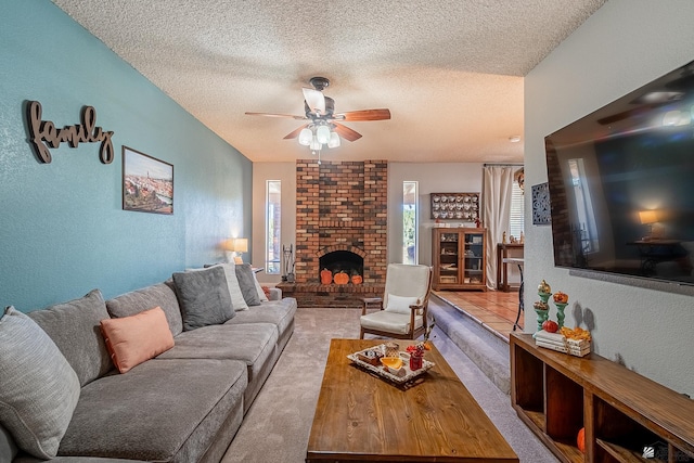 living room featuring light carpet, a fireplace, ceiling fan, and a textured ceiling