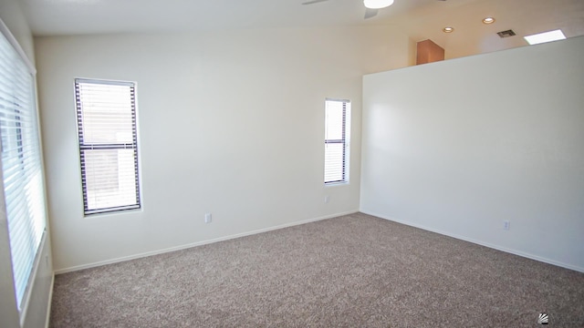 spare room featuring carpet, ceiling fan, and vaulted ceiling