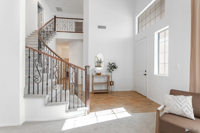 entryway with a towering ceiling and carpet