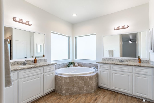 bathroom with hardwood / wood-style flooring, vanity, and plus walk in shower