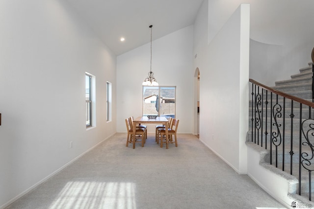 dining room with light colored carpet and high vaulted ceiling