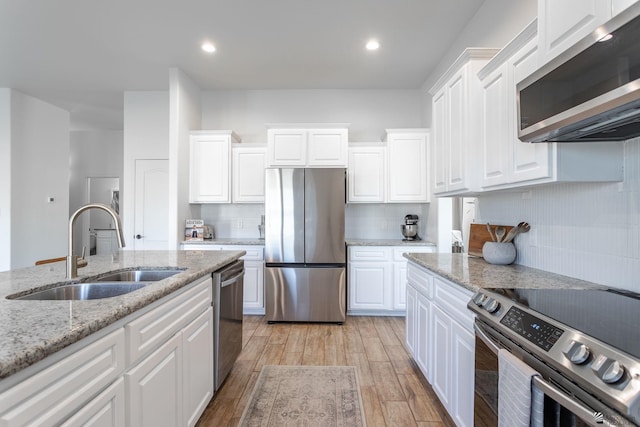 kitchen featuring sink, white cabinetry, appliances with stainless steel finishes, and tasteful backsplash