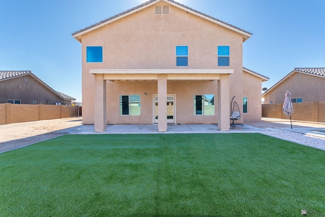 rear view of property featuring a patio area and a yard