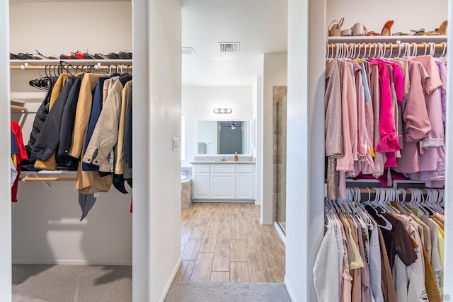 walk in closet with light wood-type flooring