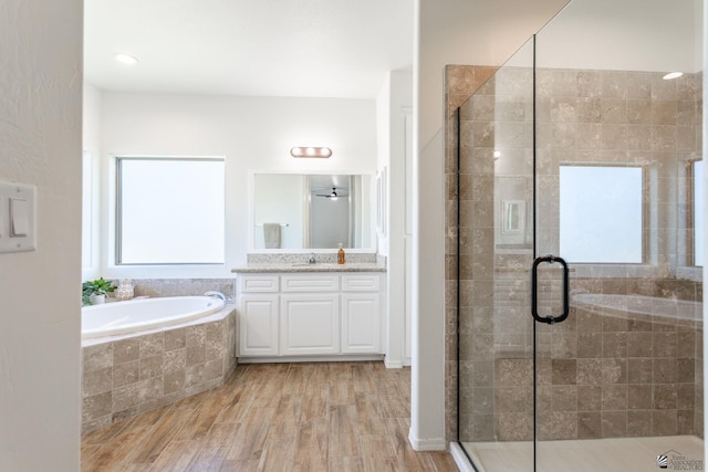 bathroom featuring wood-type flooring, plenty of natural light, vanity, and shower with separate bathtub