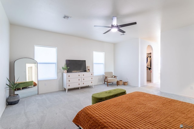 bedroom featuring a closet, ceiling fan, light colored carpet, and multiple windows